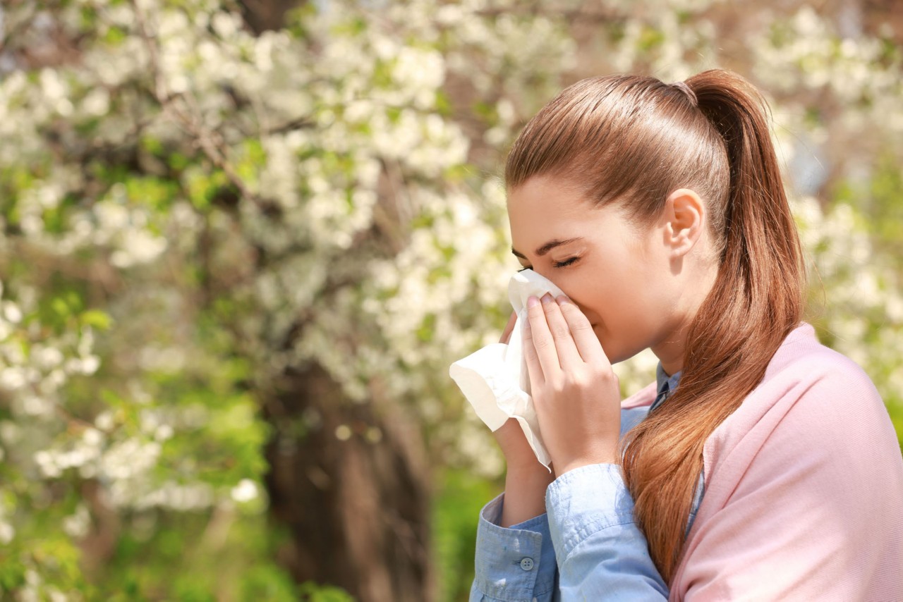 Women sneezing into tissue