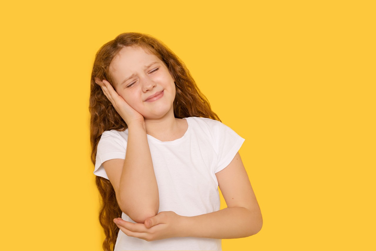 girl holding her ear - can allergies cause ear infection symptoms?